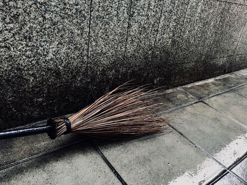 Wooden broom on the wet pavement