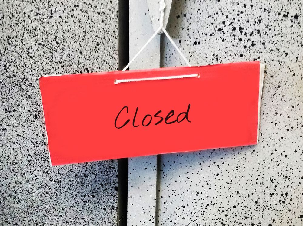 Red closed sign hanging on a door