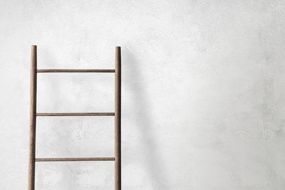 Wooden ladder leaning against a concrete wall