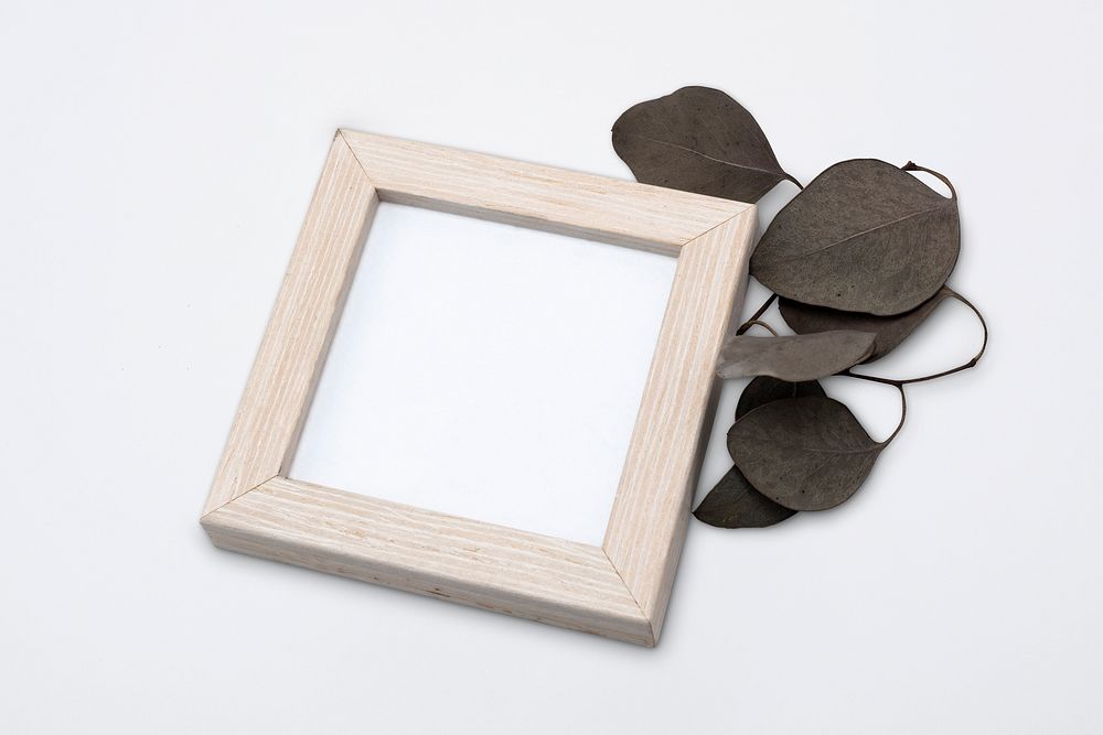 Wooden picture frame mockup psd with aesthetic dried leaf