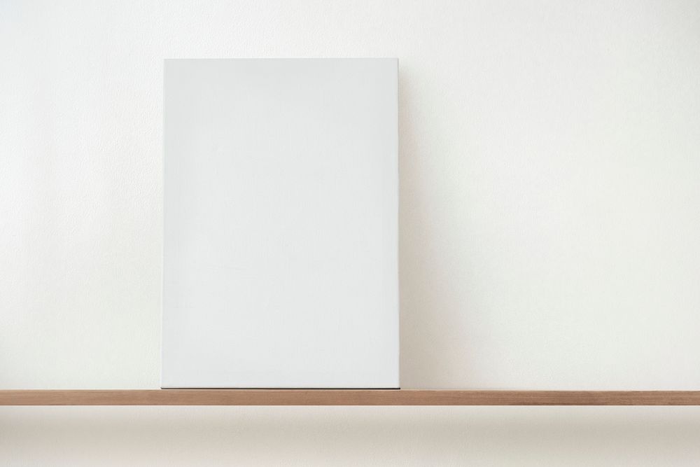 Blank white canvas on a wooden shelf