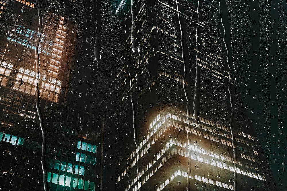 City night background, rainy window with office buildings, water texture
