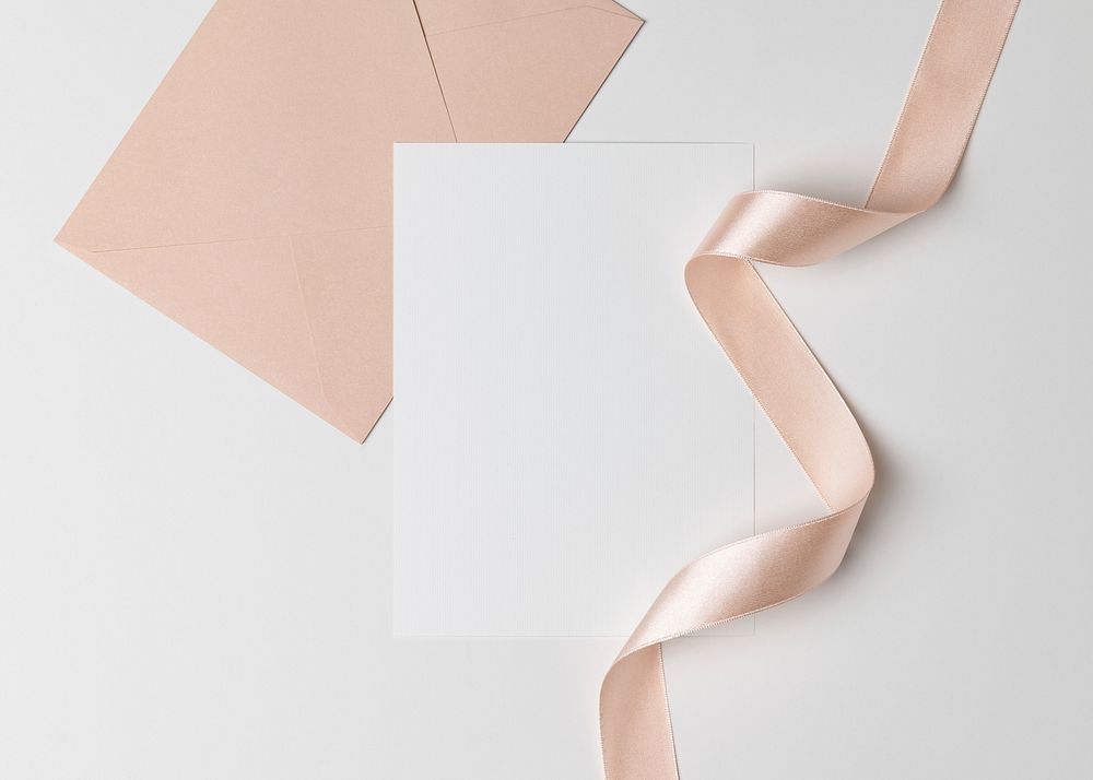 White invitation card, pink envelope, flat lay design