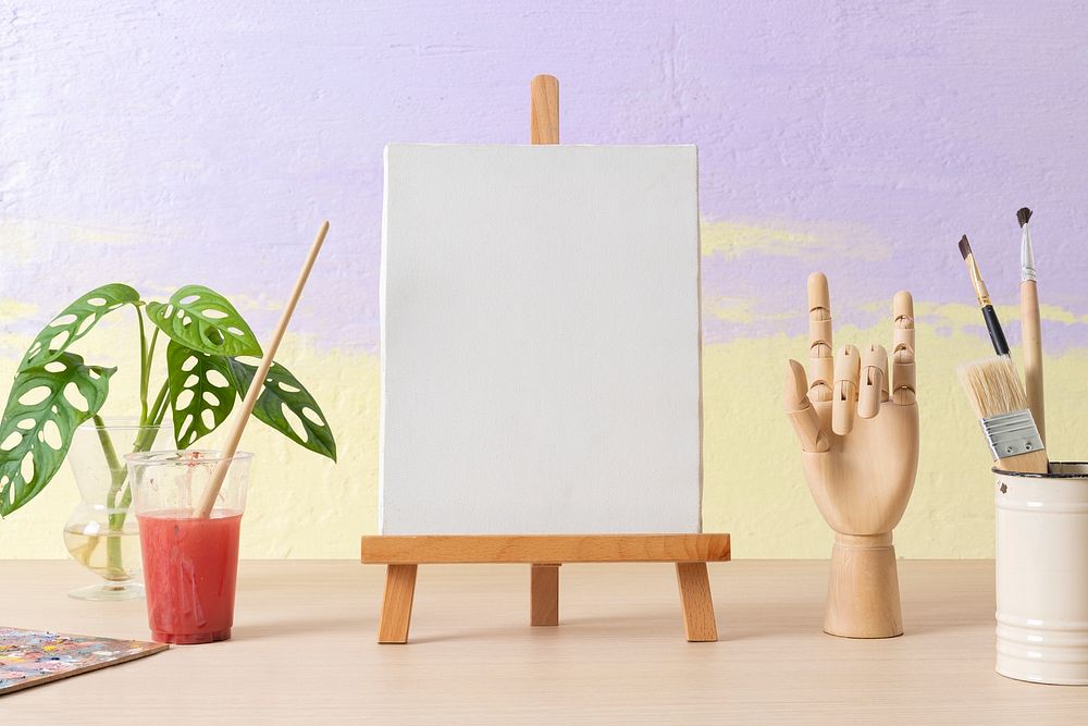 Blank canvas on easel, wood hand mannequin, drawing class decoration