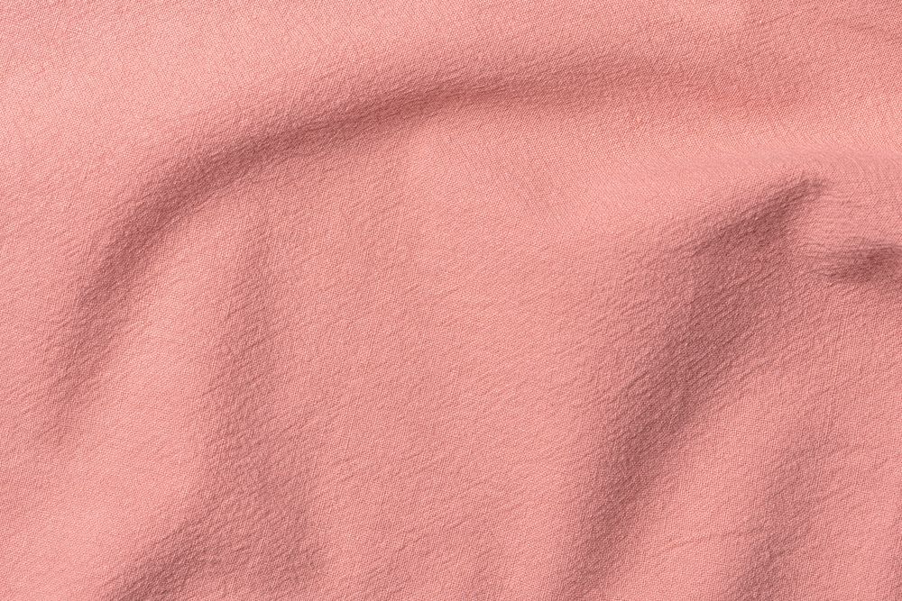 Wrinkled fabric background, salmon pink tone