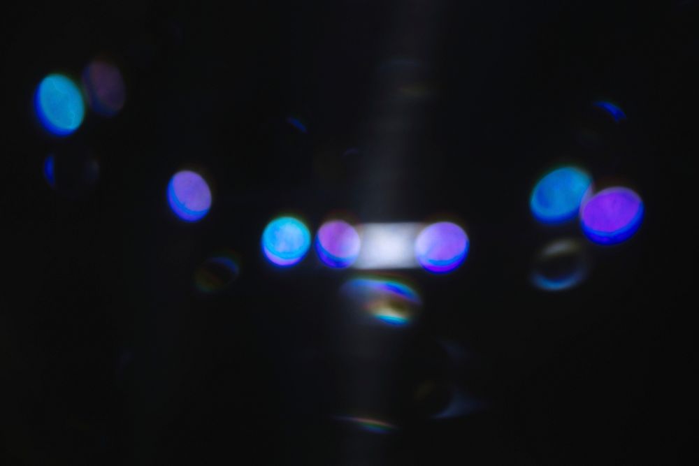 Neon lens flare prism rainbow light reflection on black background 