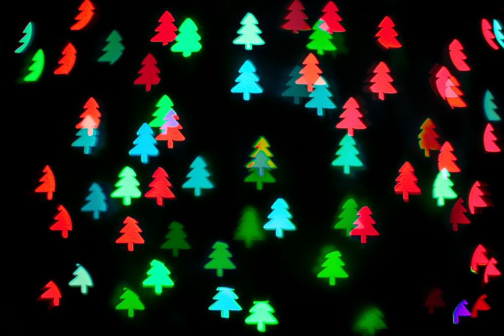Green red glitter Christmas tree bokeh sequin confetti on black background