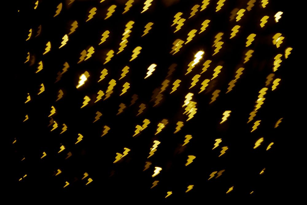 Gold glitter lighning bokeh sequin confetti on black background