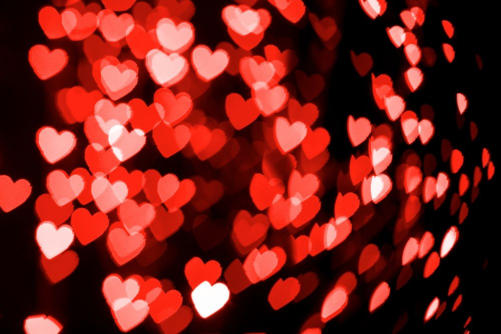 Red glitter heart bokeh sequin confetti on black background
