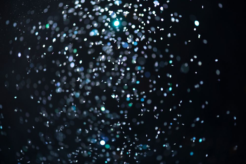 Blue falling glitter sequin confetti on black background