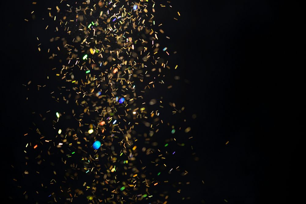 Gold falling glitter sequin jewel confetti on black background