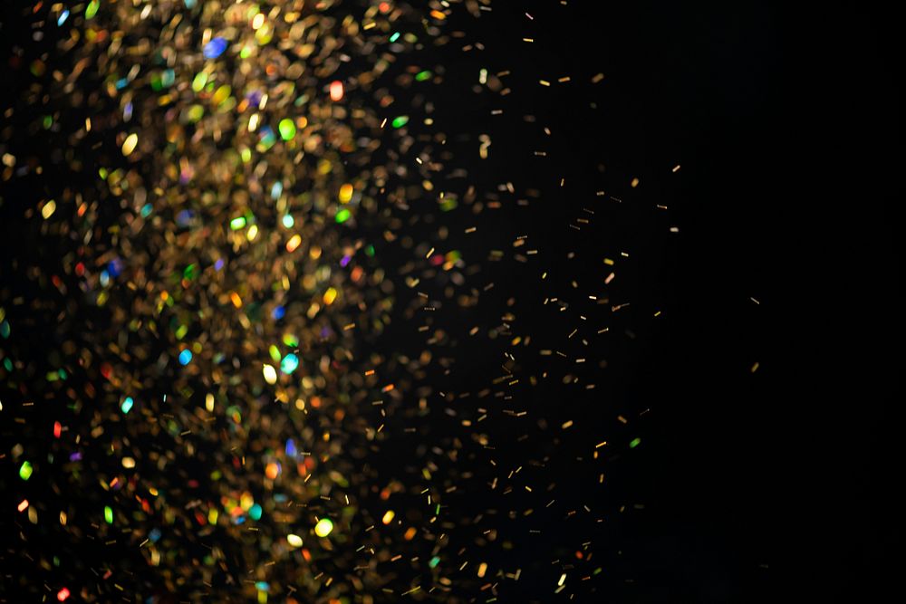 Gold falling glitter sequin jewel confetti on black background
