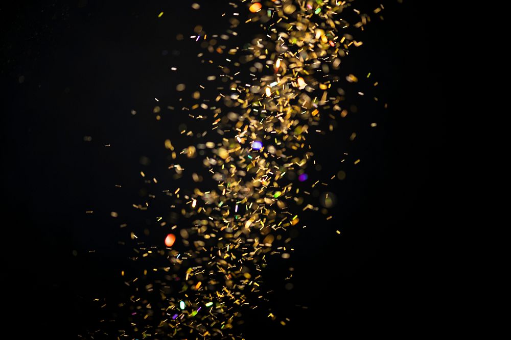 Gold falling glitter sequin jewel confetti on darl black background