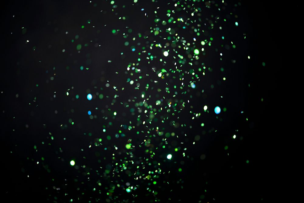 Green falling glitter sequin confetti on black background