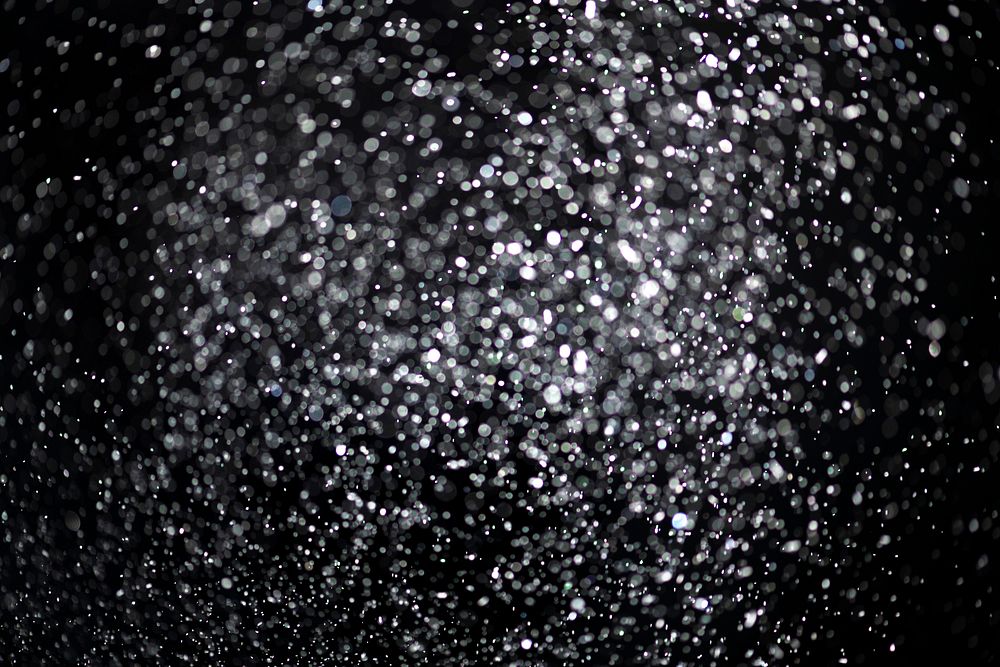 White falling glitter sequin confetti on black background