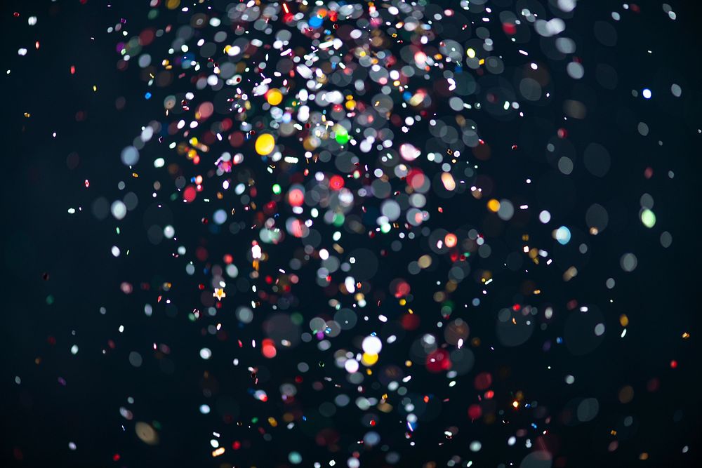 Colorful falling glitter sequin confetti on black background