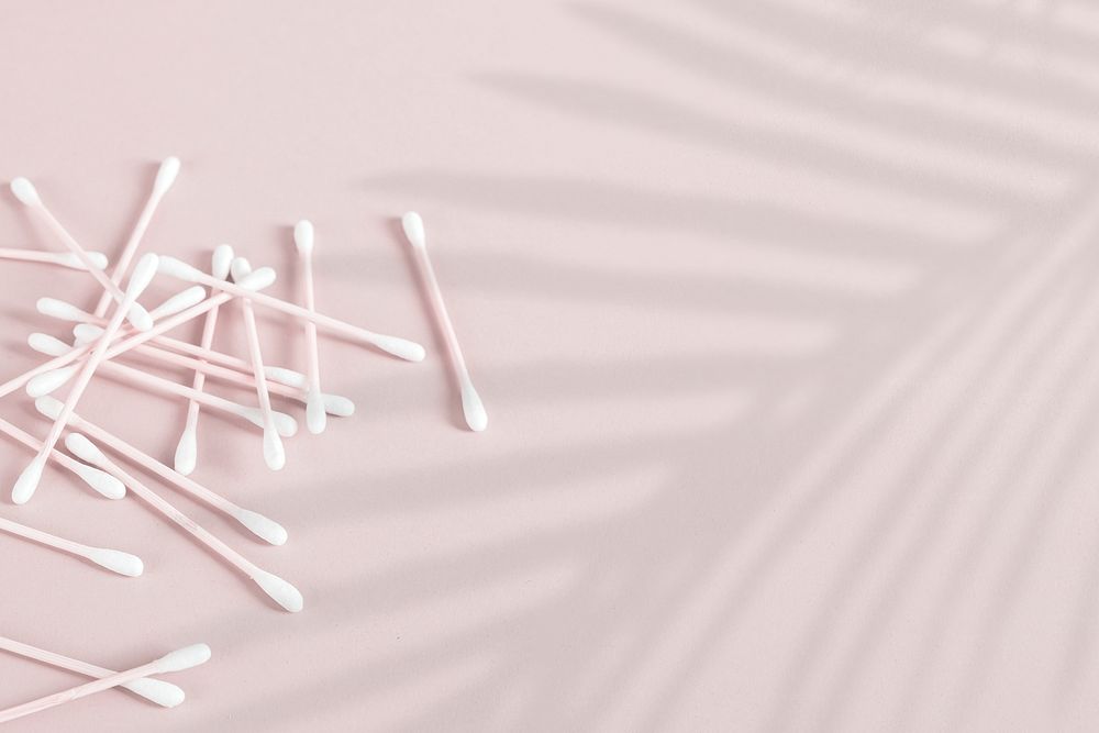 Natural cotton buds on pink background