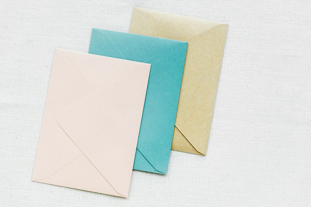 Colorful envelopes on white fabric textured background