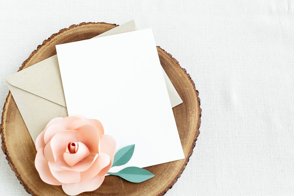 Blank white card  on a wooden plate with a rose