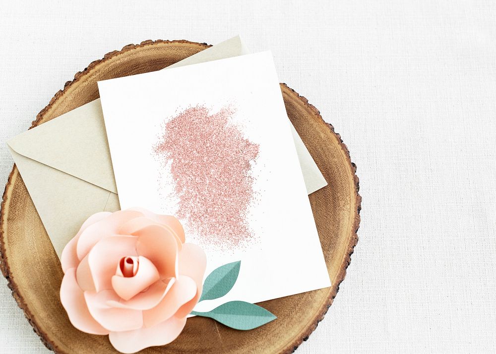 White card template mockup on a wooden plate with a rose