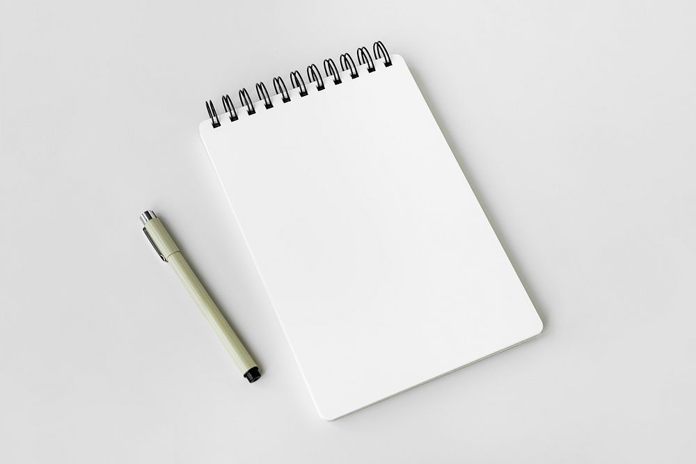 Blank plain white notebook with a pen