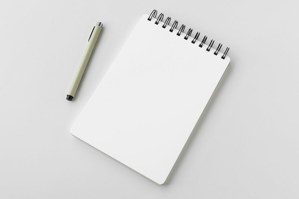 Blank plain white notebook with a pen