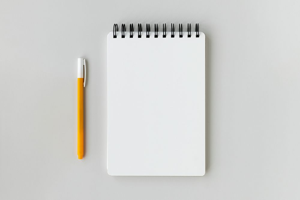 Blank plain white notebook with a yellow pen
