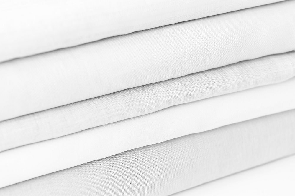 Stack of folded gray and white woven fabric patterned background