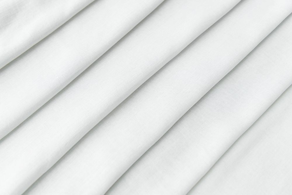 Stack of folded white woven fabric patterned background