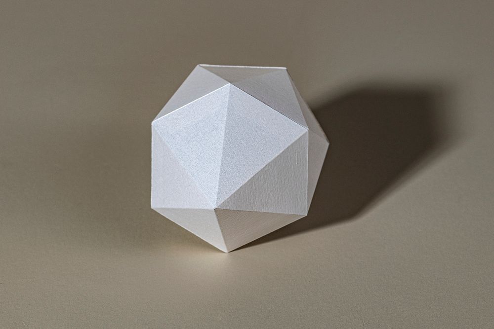 3D silver hexagon shaped paper craft on a beige background