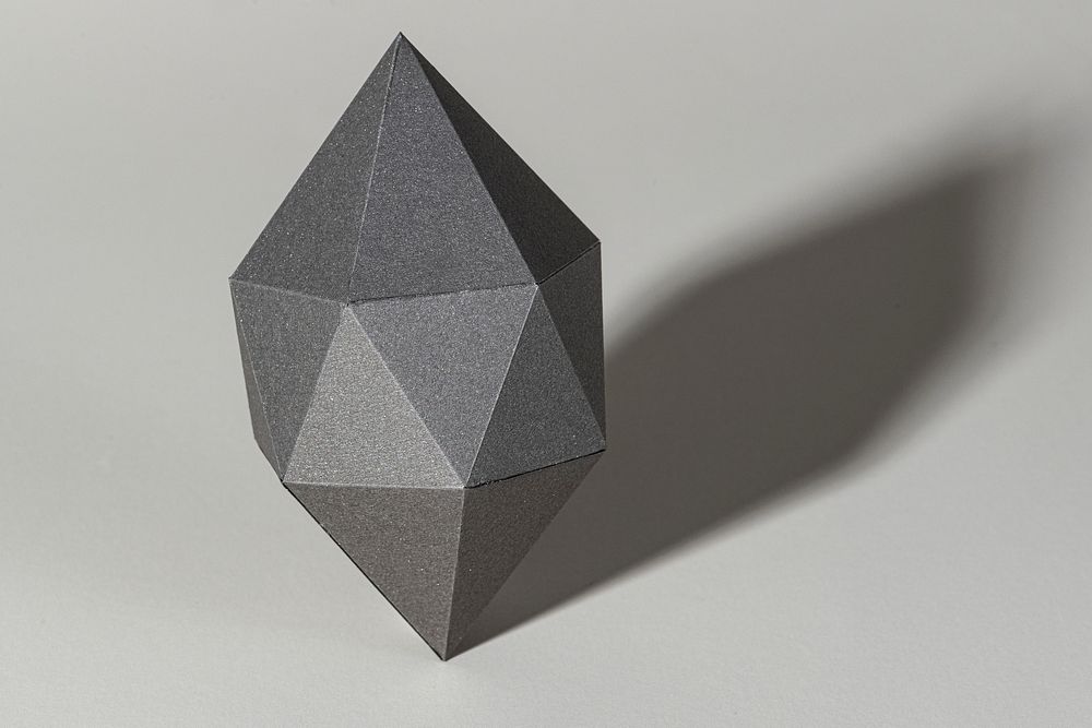 3D gray octahedral polyhedron shaped paper craft on a gray background