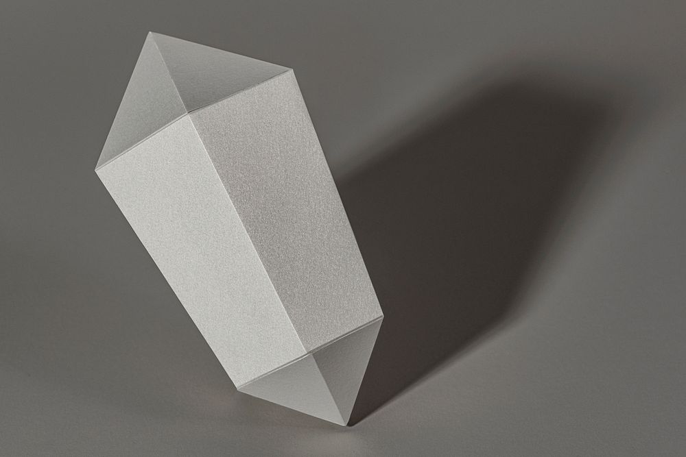 Silver hexagonal prism paper craft on a gray background