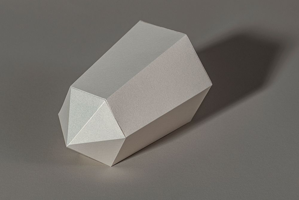 Silver hexagonal prism paper craft on a gray background