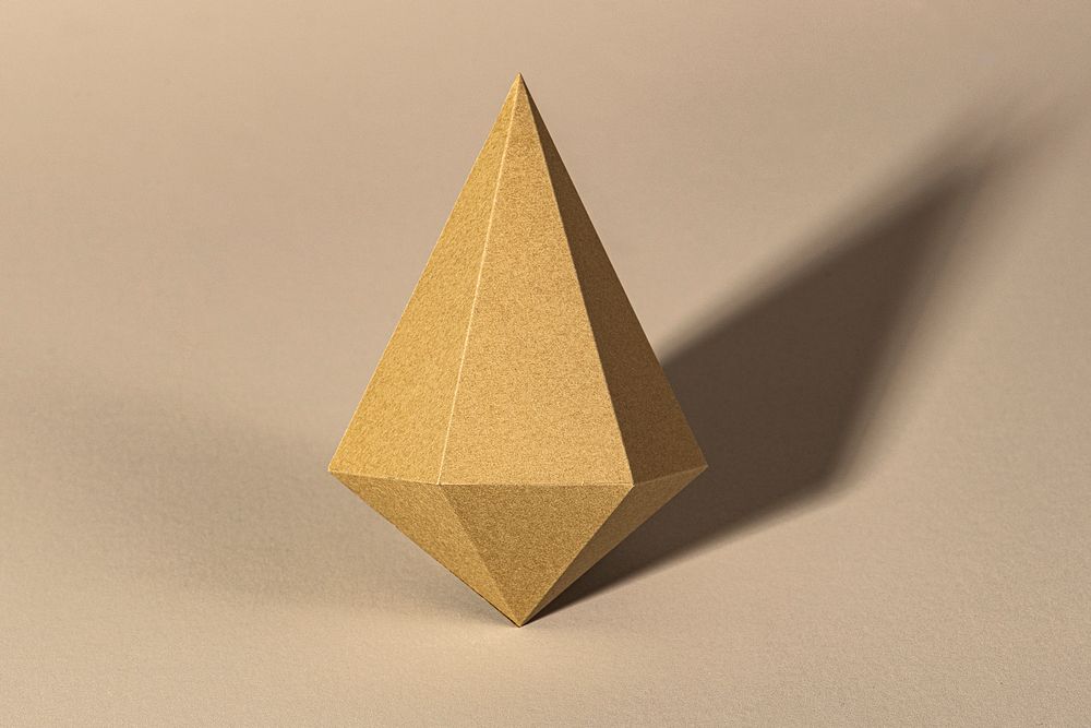 3D golden asymmetric hexagonal bipyramid paper craft on a beige background