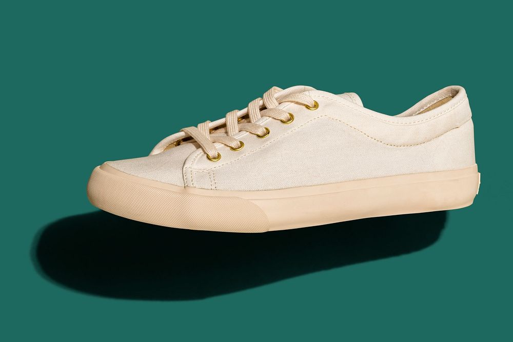 Unisex cream colored sneakers mockup on a teal background