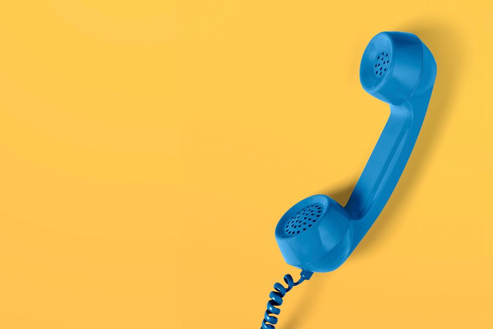 Retro blue corded phone on a yellow background 