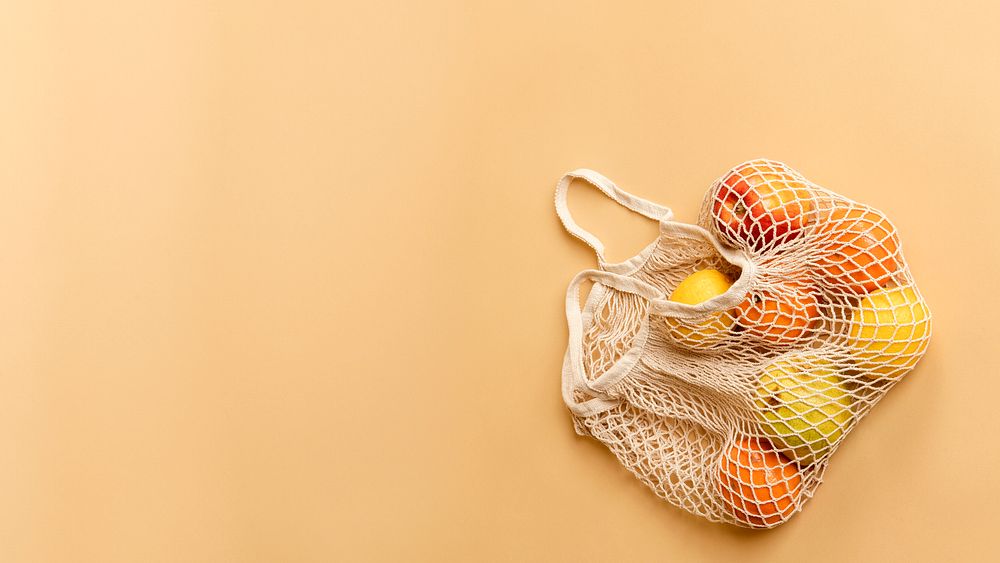 Reusable net bag with fruits on an orange background