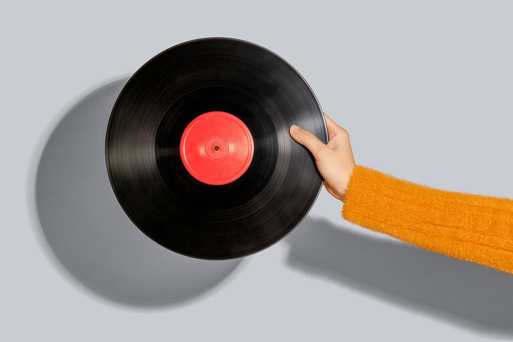 Woman holding a vinyl record mockup on a gray background