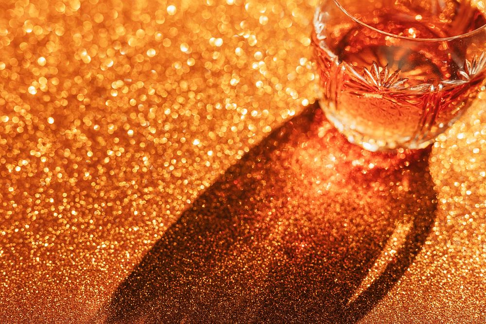 Whisky in a glass on a golden background 