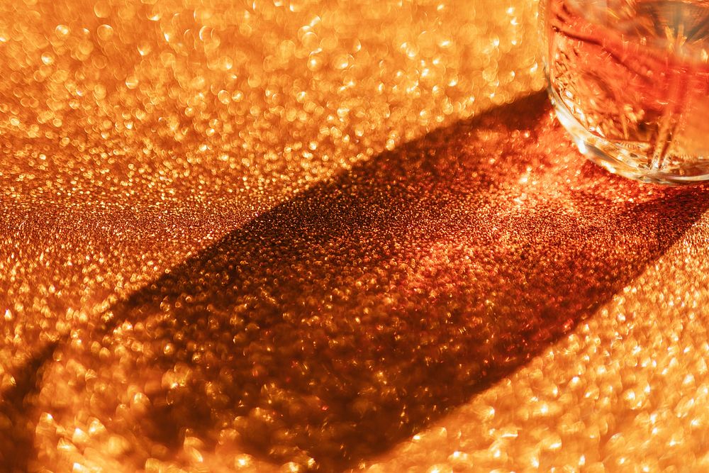 Whisky in a glass on a golden background 
