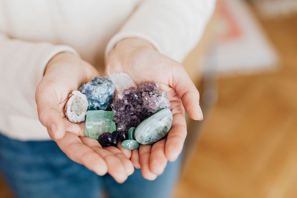 Woman with a hand full of healing crystals