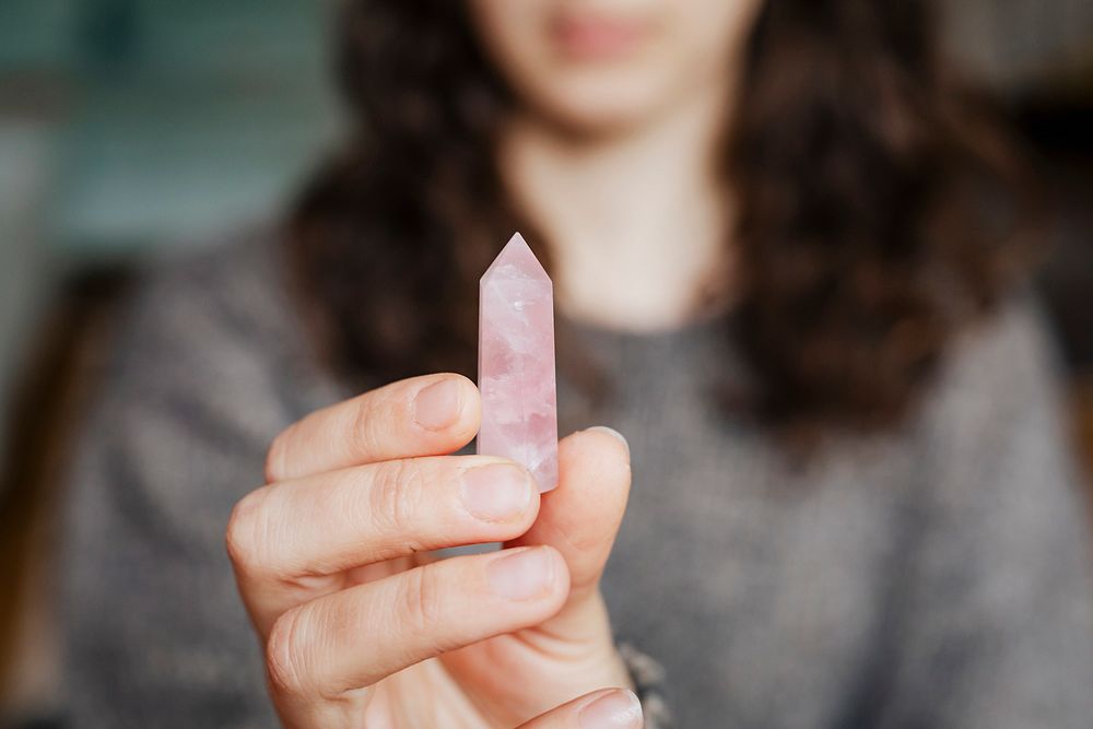 Woman holding a rose quartz crystal