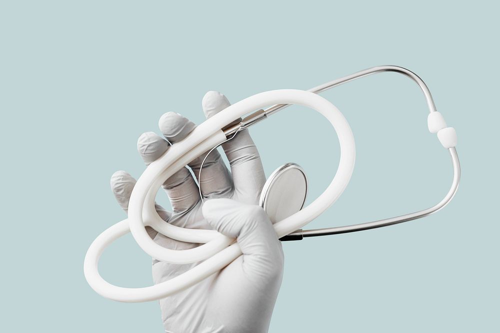 Hand with latex glove holding a stethoscope duting a virus outbreak