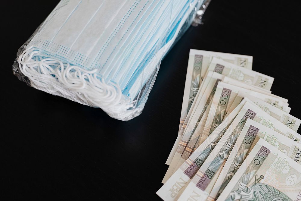 Polish Zloty banknotes and face masks on a black table