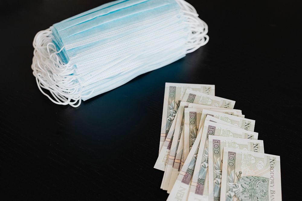 Polish Zloty banknotes and face masks on a black table