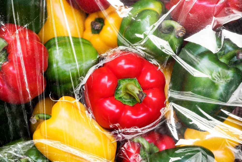 Fresh bell peppers covered with plastic wrap textured wallpaper background
