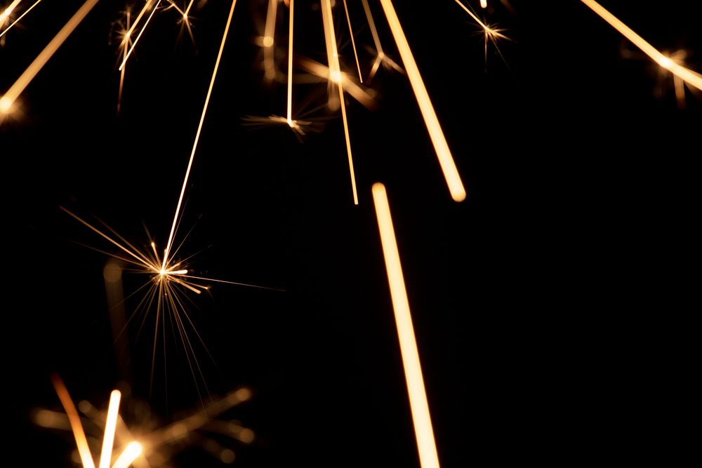 Burning sparkler on a black background wallpaper