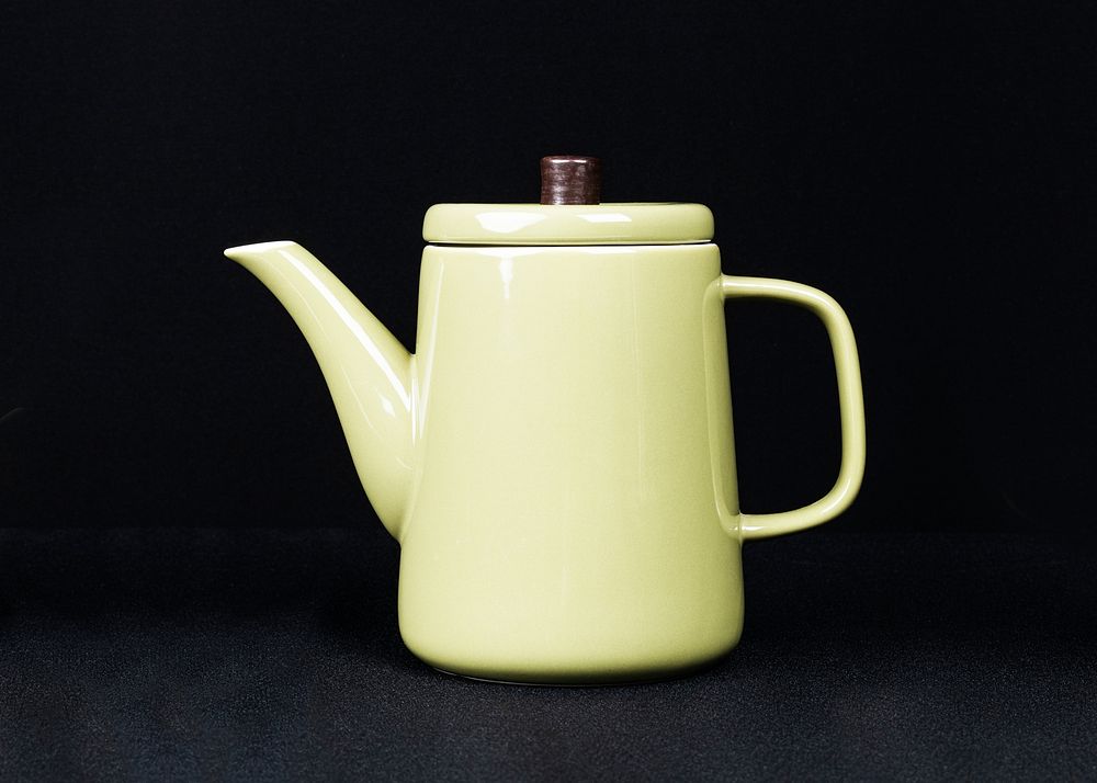 Green ceramic kettle on black backgrounds