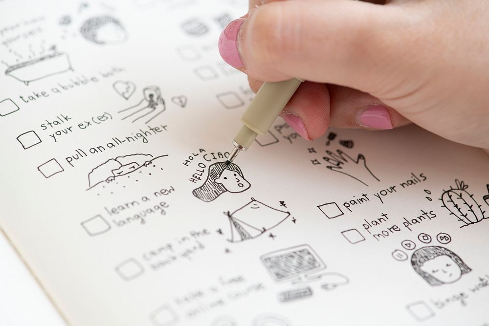 Girl doodling and making a checklist in a notebook