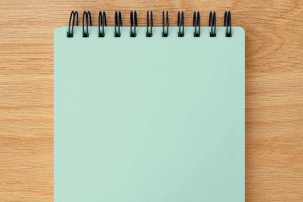 Mint green ruled notebook mockup on a wooden table